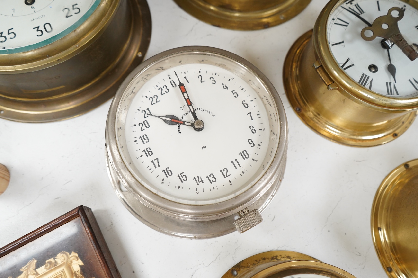A ship's clock by Story of Barrow, a CCCP ship's clock and four other brass examples, some with keys, largest 28cm in diameter